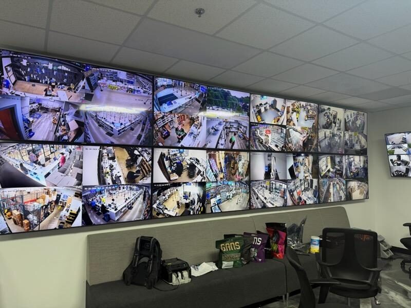Eight-screen command wall showing warehouse and retail camera feeds