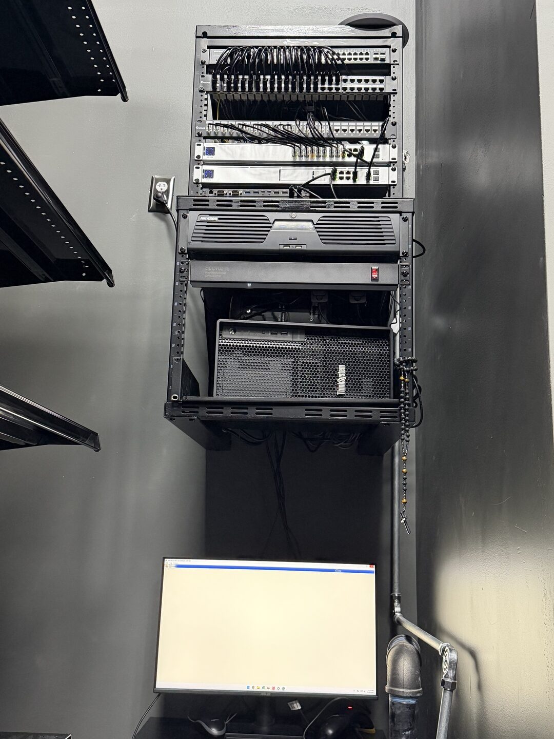 Wall-mounted network rack with patch panels, switches, Hikvision NVR and server